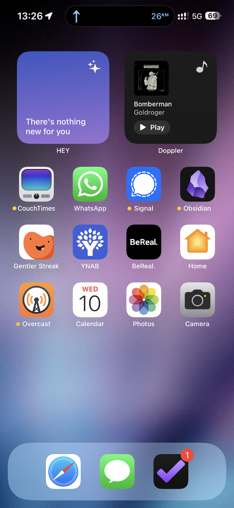 An iOS home screen with a noisy purple-blue wallpaper and two small widgets at the top: HEY and Doppler. Then there’s three rows of apps: CouchTimes, WhatsApp, Signal, Obsidian, Gentler Streak YNAB, BeReal, Home, Overcast, Calendar, Photos, Camera. The Dock has three apps: Safari, Messages and OmniFocus.